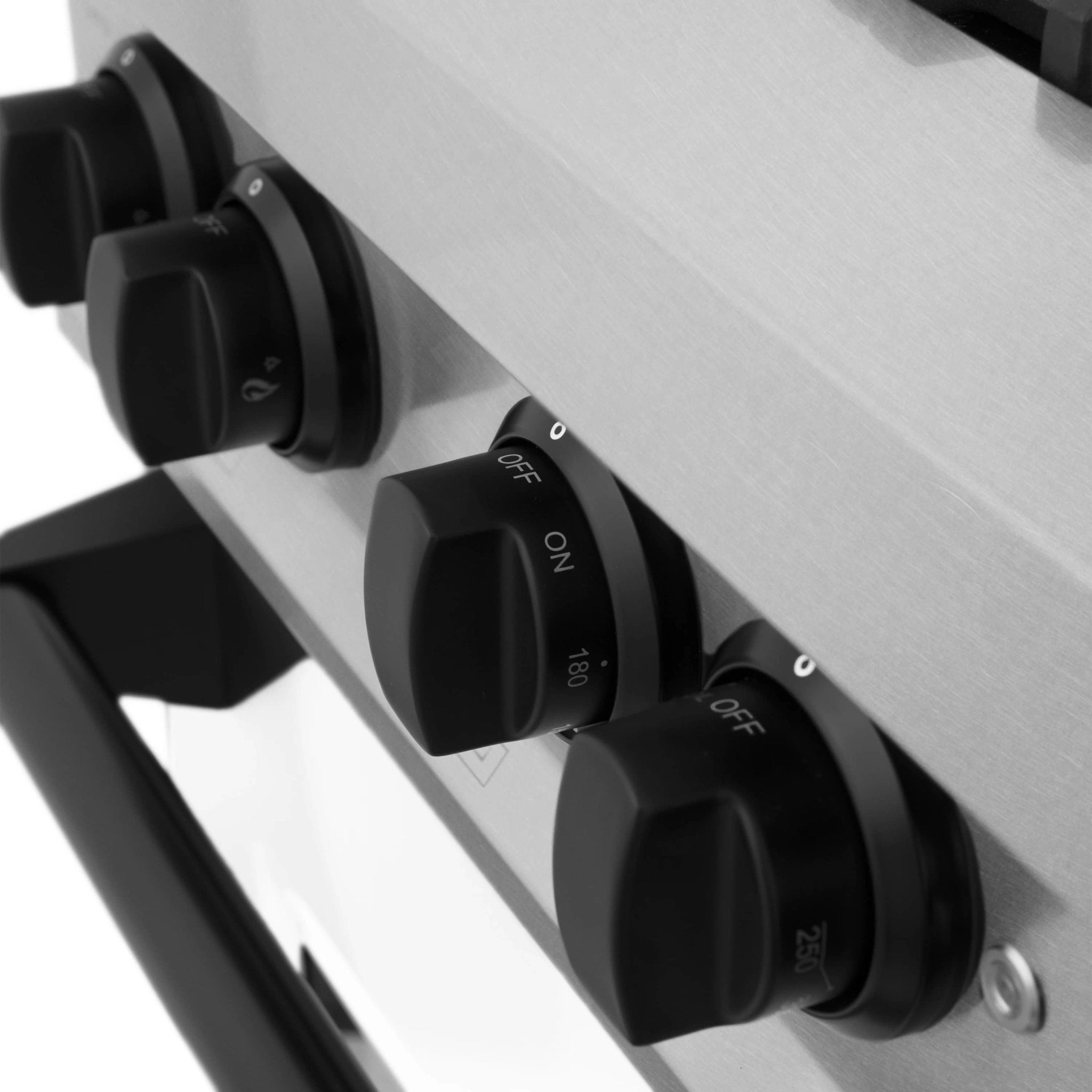 Gas range control knobs, black dials on white stainless front panel