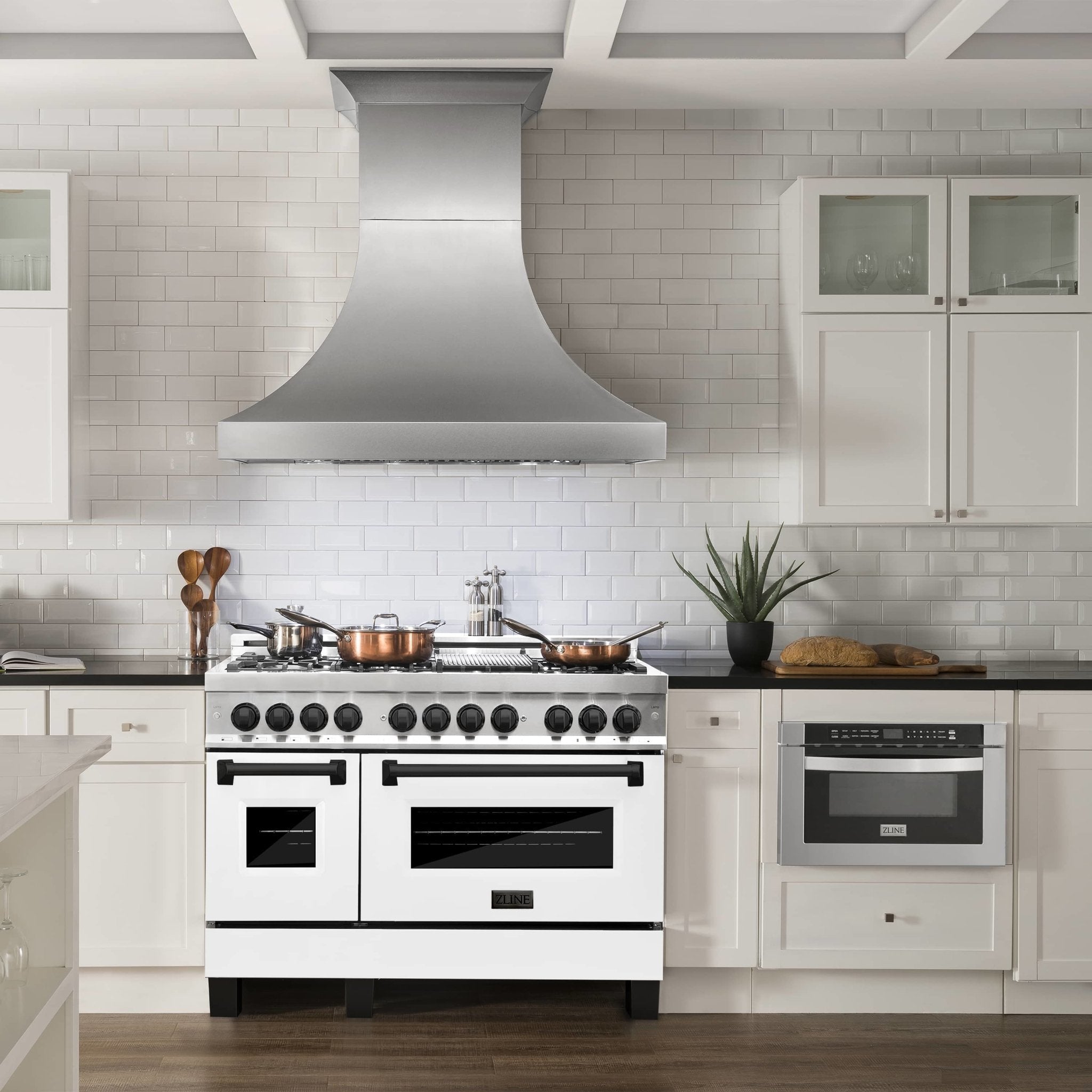 Dual-fuel range with white matte doors, black knobs, and stainless trim in kitchen