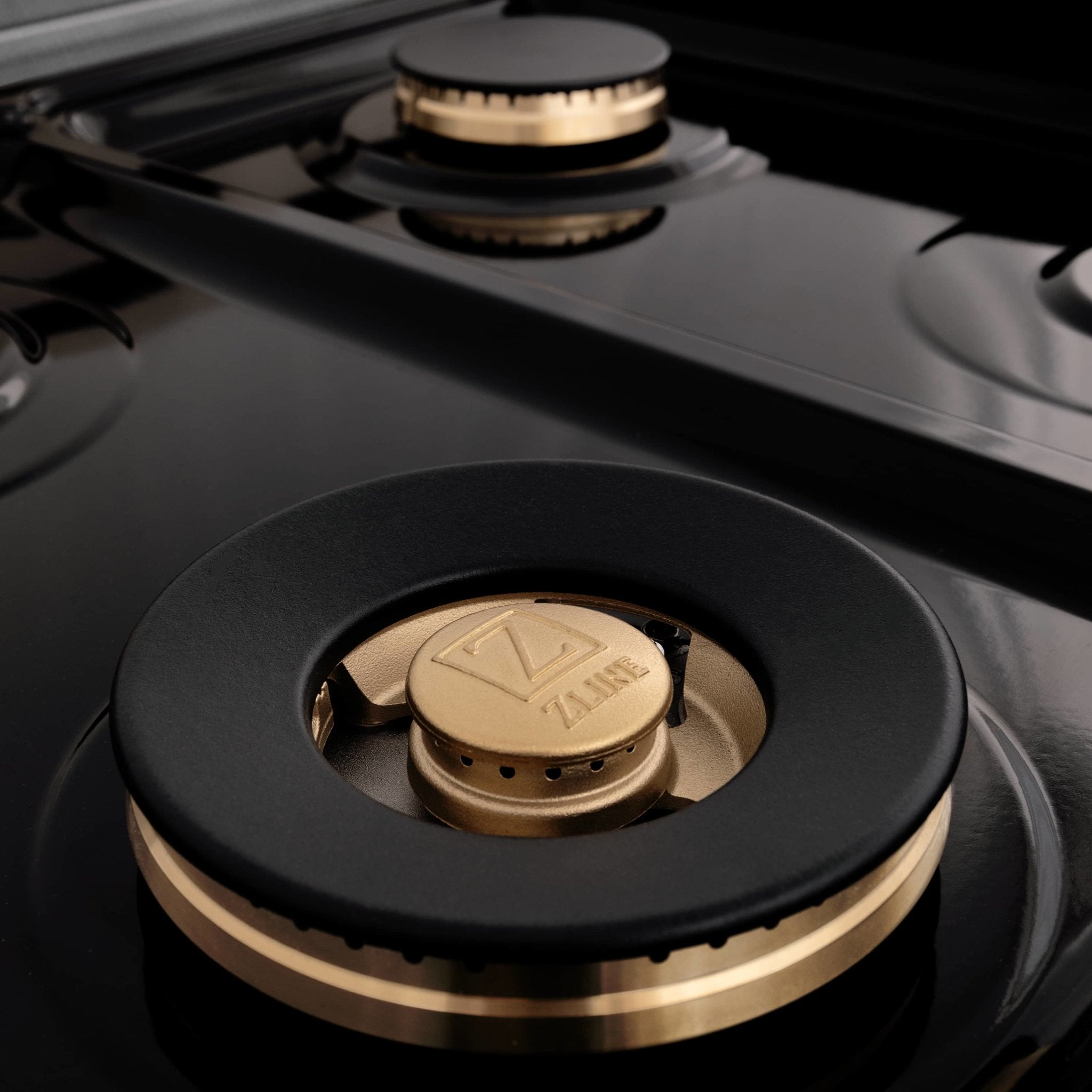 Single gas burner with black cap and gold ring on stainless range