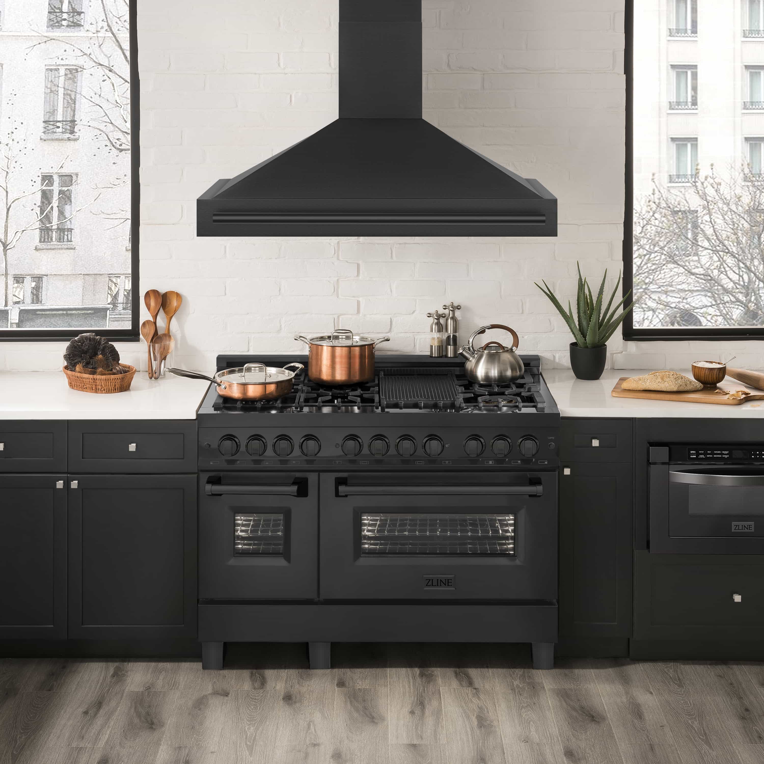 Black wall mount range hood above the cooktop with an angled chimney chimney body