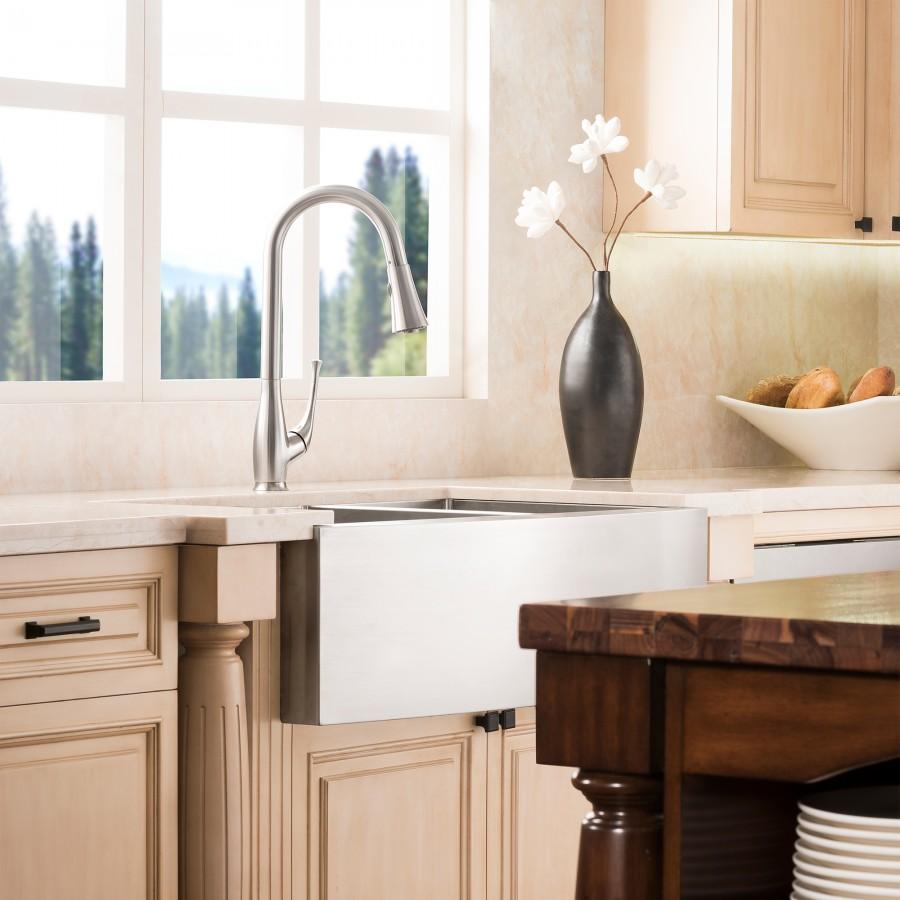 Brushed nickel kitchen faucet with tall curved spout and side sprayer