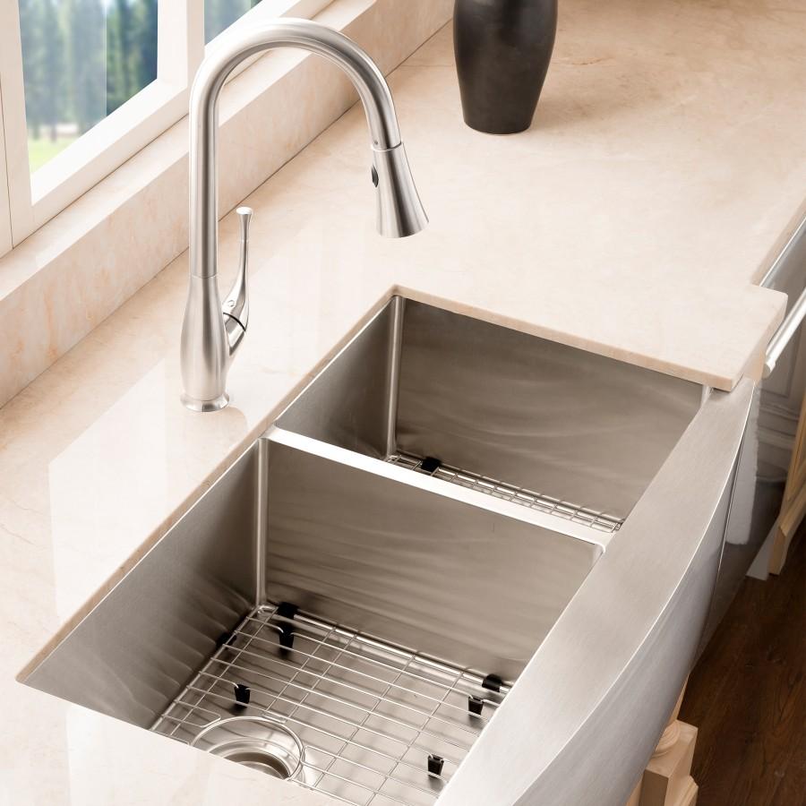 Brushed nickel kitchen faucet with tall curved spout over stainless sink basin
