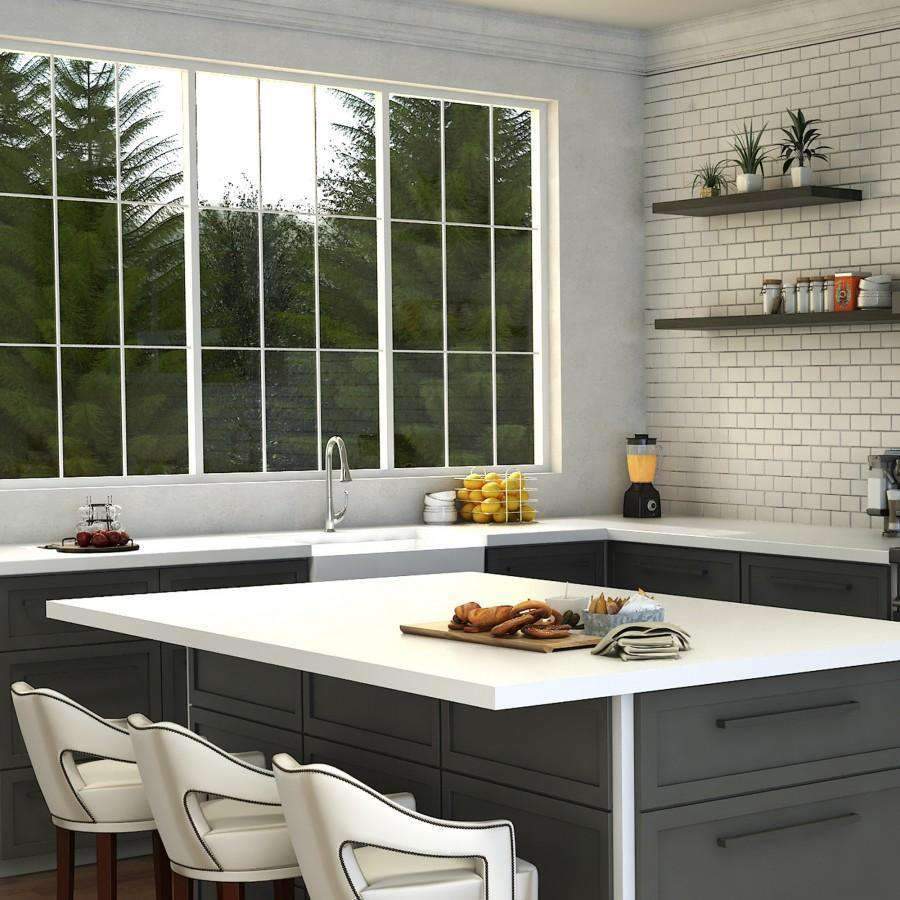 Chrome kitchen faucet over white countertop, curved spout and single handle, room view