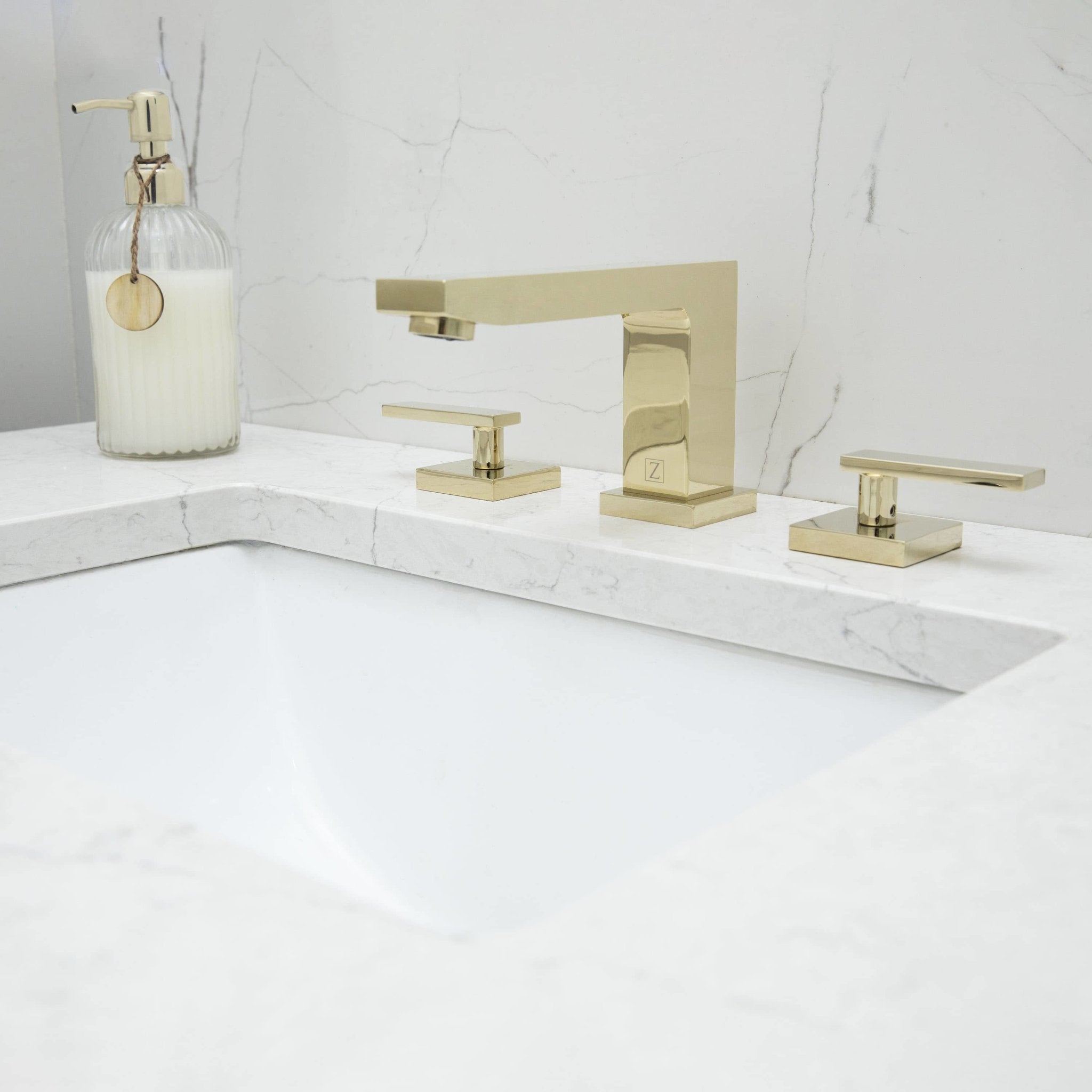 Polished gold three-piece bath faucet with deck-mount spout and side handles