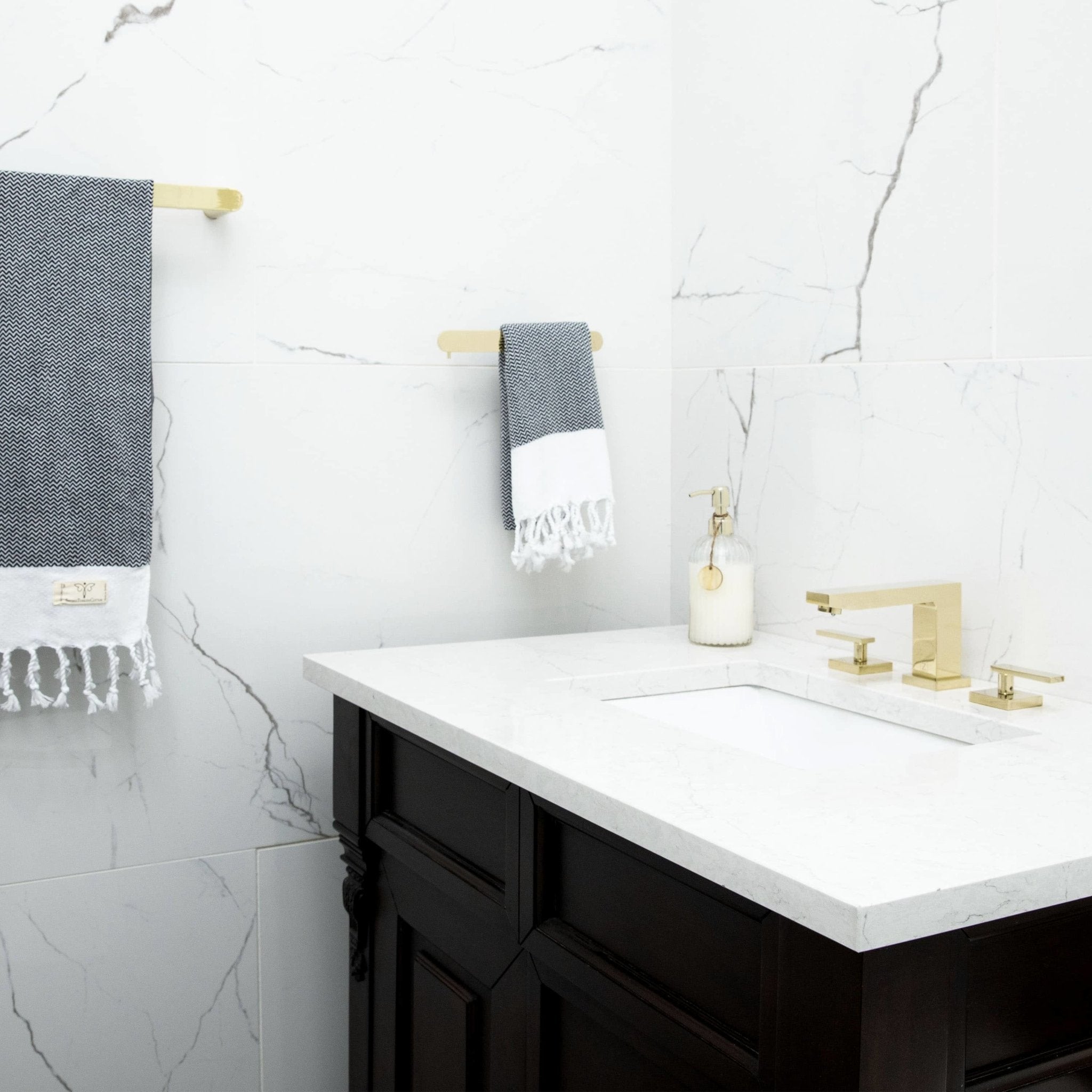 Bathroom wall with polished gold towel rail, toilet paper holder, and towel hook set