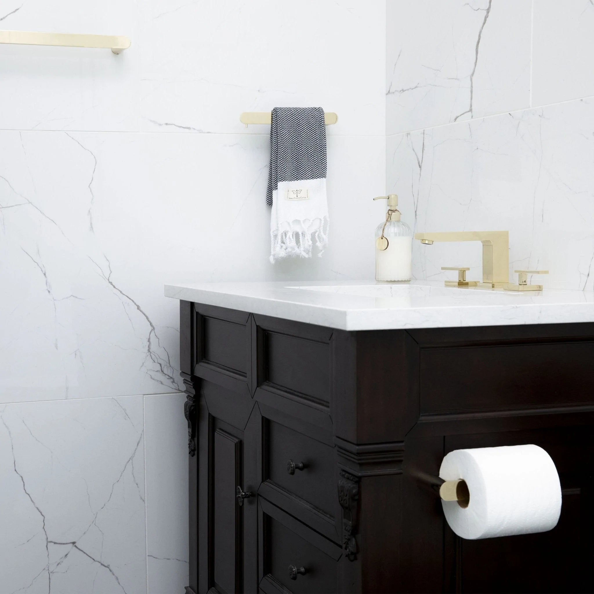 Brushed nickel toilet paper holder on dark vanity, holding a white roll