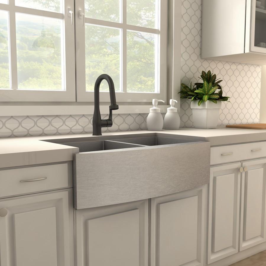 Matte black kitchen sink faucet with high-arc spout mounted on apron-style sink