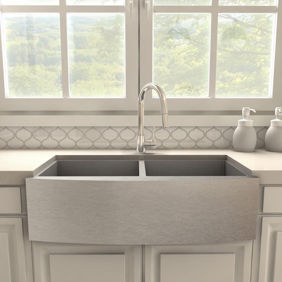 Chrome kitchen faucet with arched spout centered over gray sink