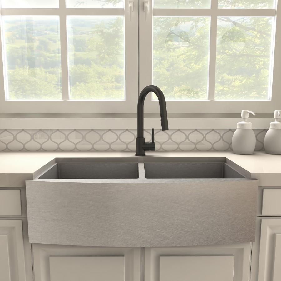 Matte black kitchen faucet with arched spout and single lever, installed on a double sink