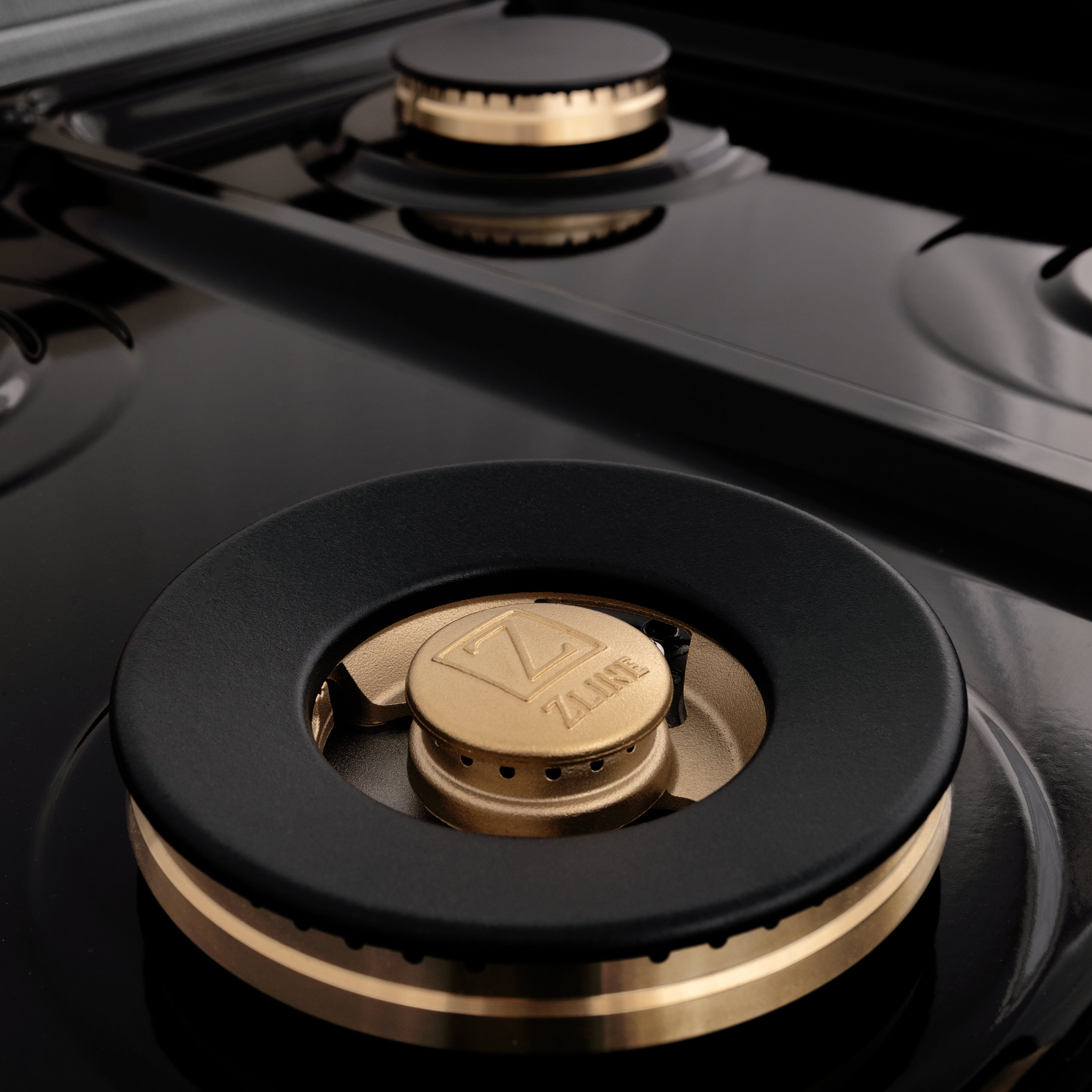 Close-up of brass burner cap centered on black cast-iron style grate