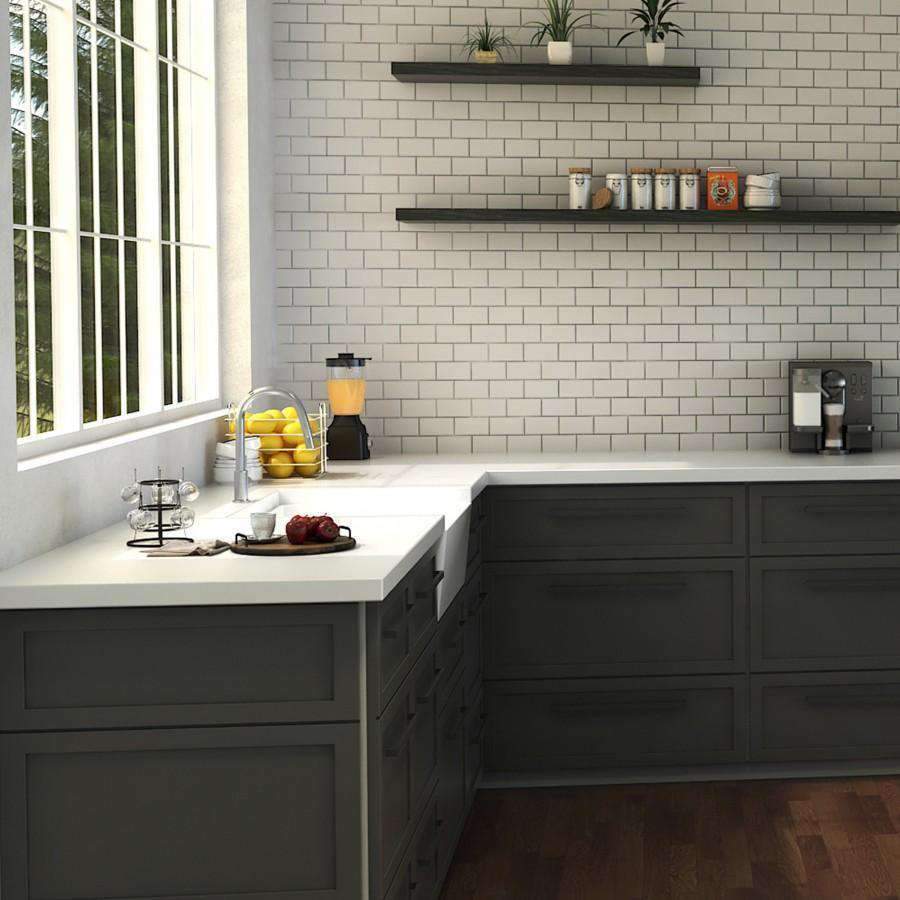 Chrome kitchen faucet with tall curved spout on a white countertop near backsplash