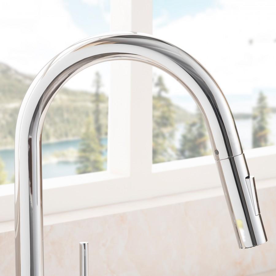 Close-up of chrome faucet spout rising over the sink with glossy finish