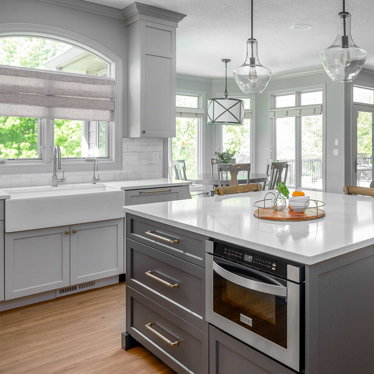 Chrome kitchen faucet with tall curved spout in a modern white countertop sink area