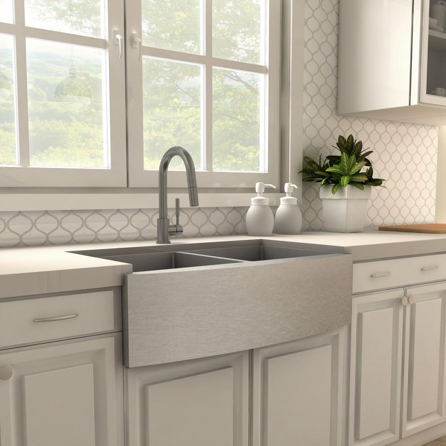 Gun metal kitchen faucet with arched spout over a farmhouse double sink