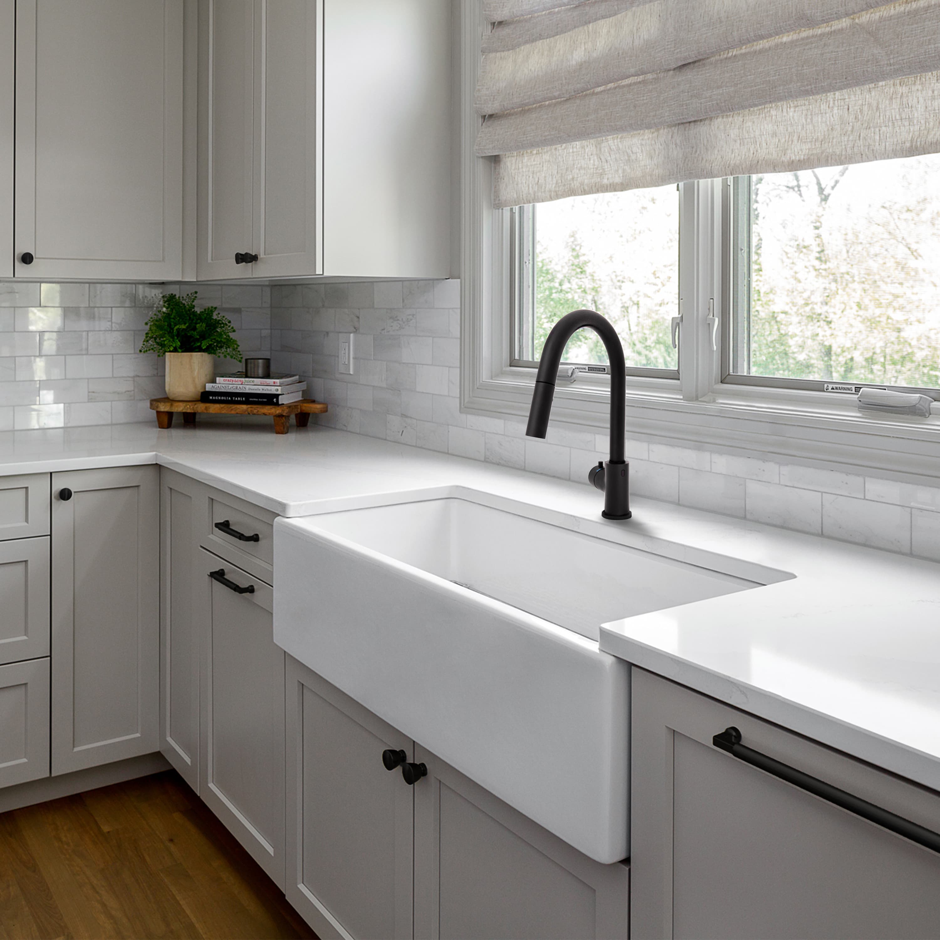 Matte black kitchen faucet mounted over white sink in a modern kitchen
