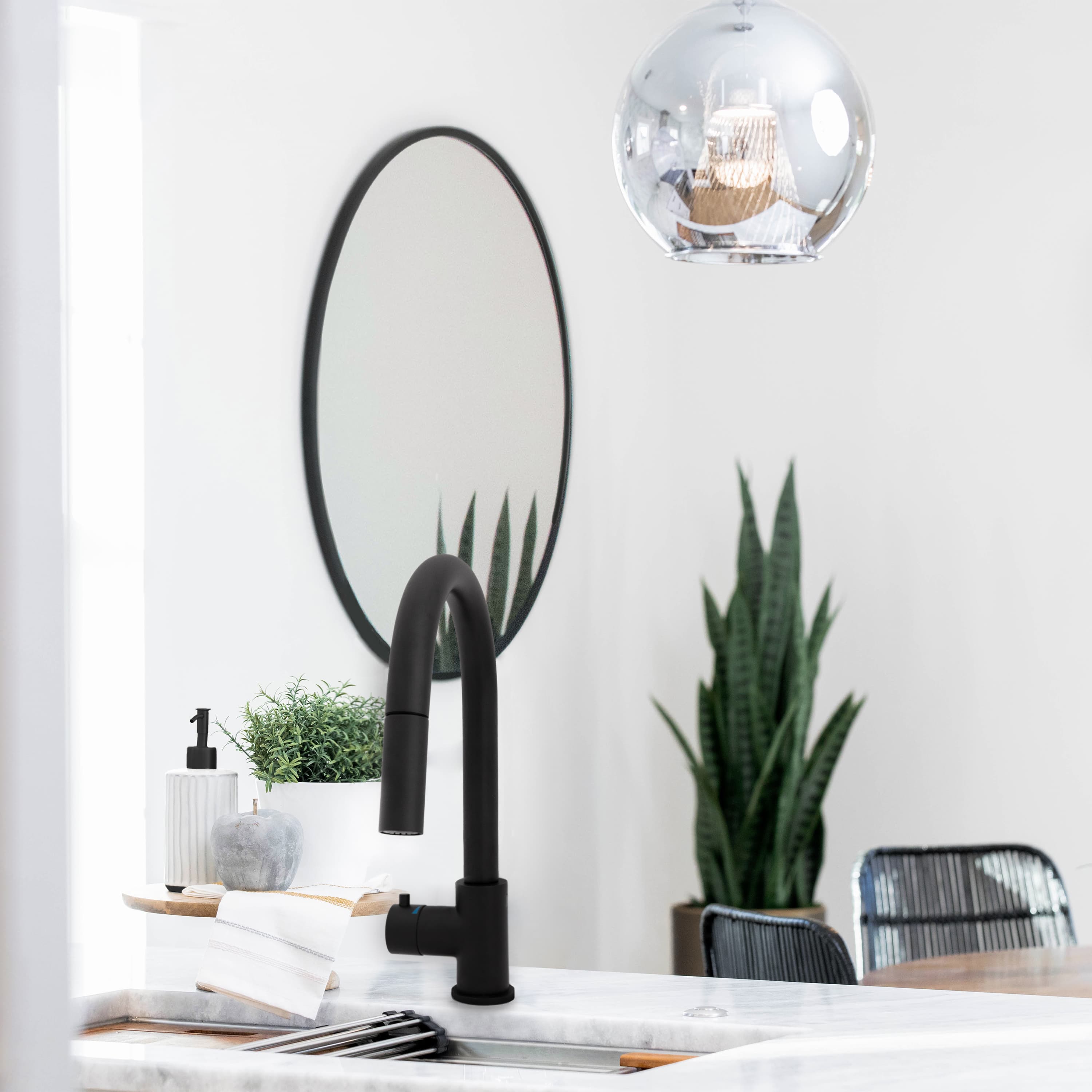 Matte black touchless kitchen faucet on countertop beside the sink