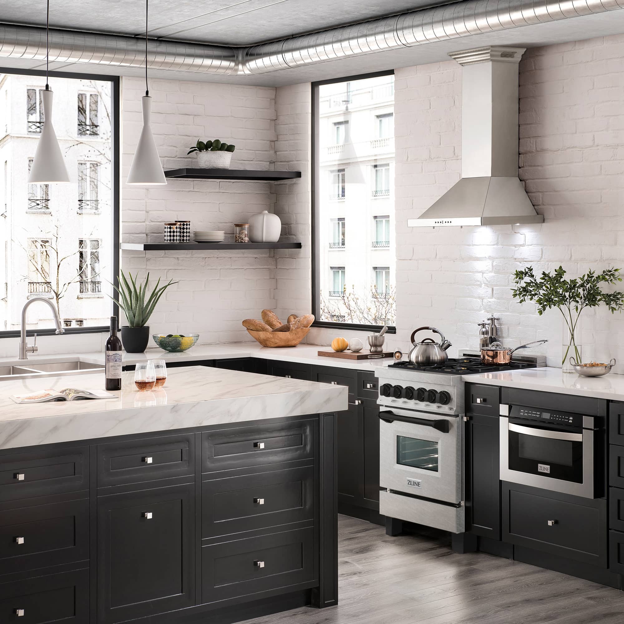 Dual fuel range setup in a bright kitchen with black cabinets and built-in appliances