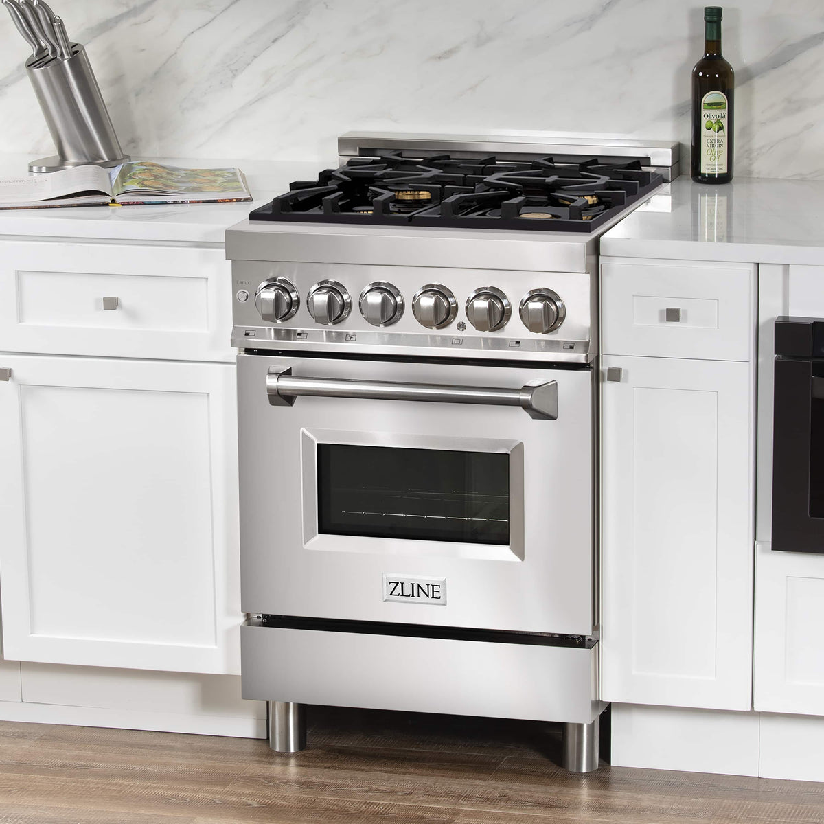 Stainless steel dual fuel range with black gas grates, brass burner caps, and oven door