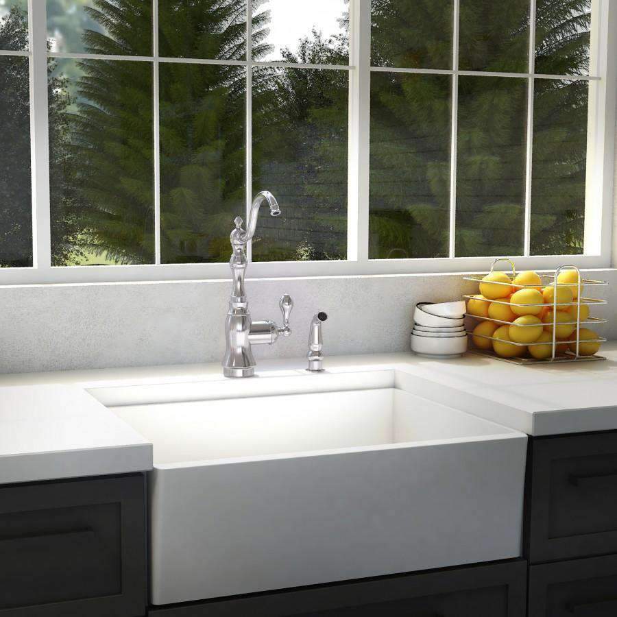 Chrome kitchen faucet with arched spout and two handles on white sink