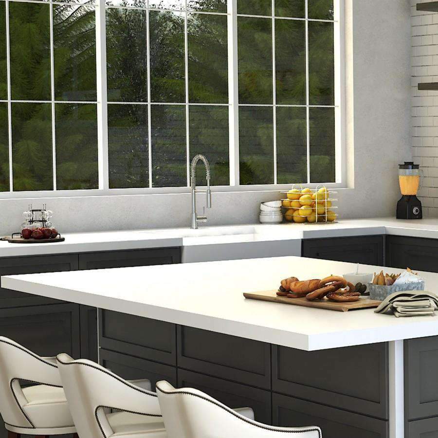 Chrome kitchen faucet with arched pull-down sprayer over a white sink