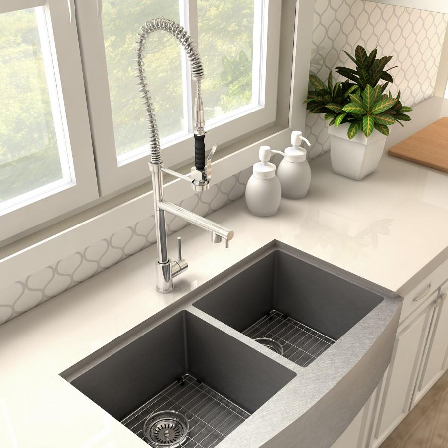Chrome kitchen faucet above double-basin sink with coiled spring sprayer