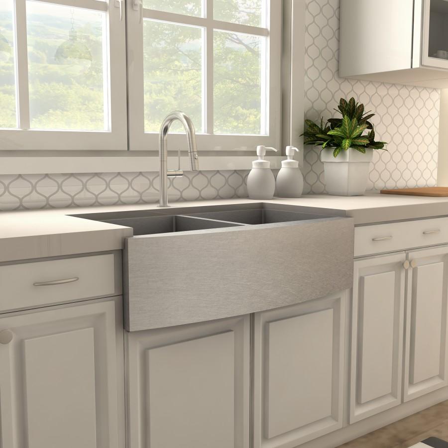 Brushed nickel kitchen faucet centered above a gray farmhouse sink