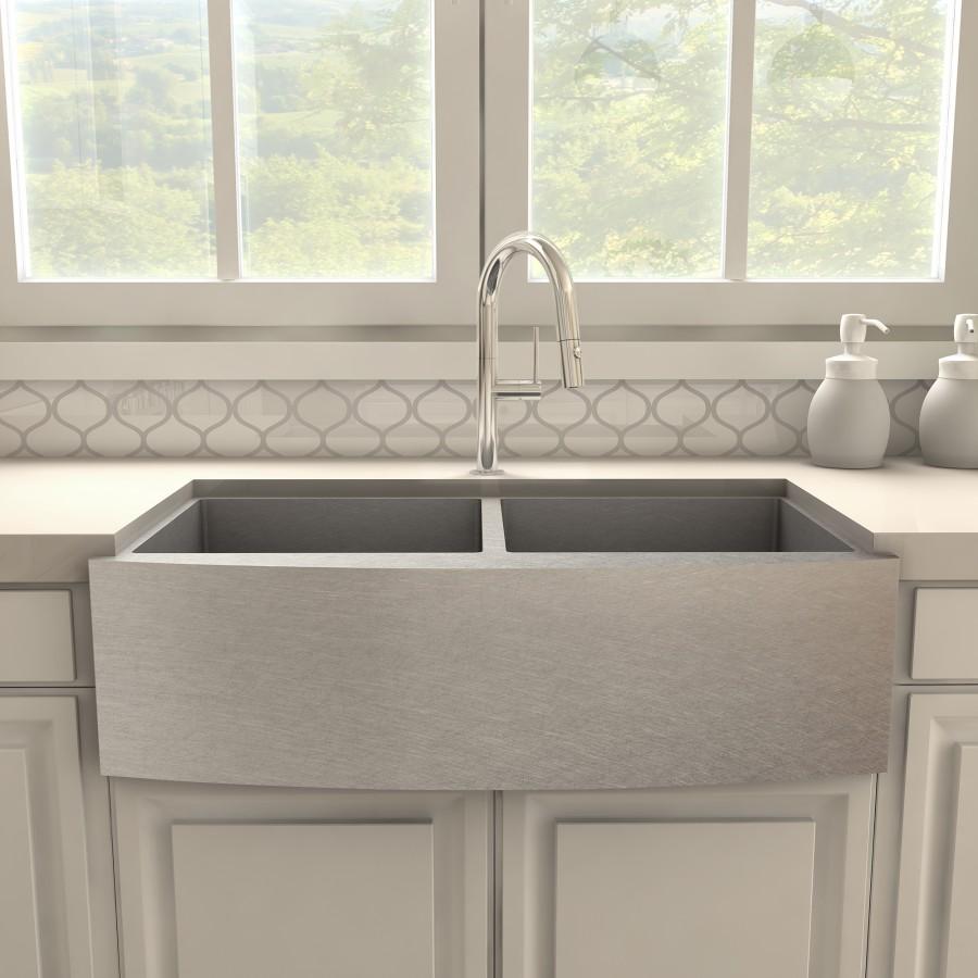 Chrome kitchen faucet with tall arched spout centered over apron-front sink